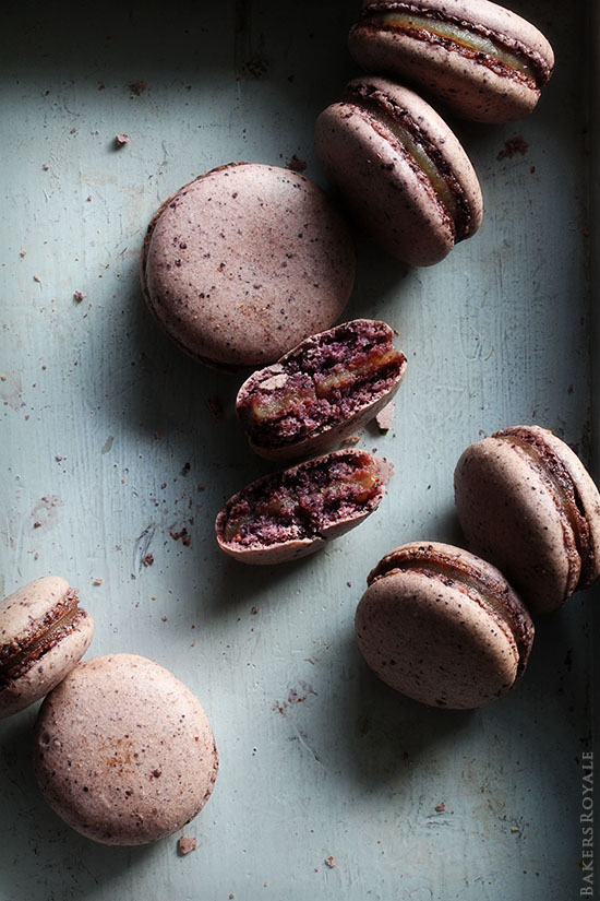 8 Blueberry Macarons on a counter.